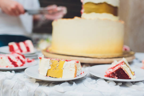 istock Three-tiered white wedding cake decorated with flowers from mastic on a white wooden table. Picture for a menu or a confectionery catalog with copy space. 1177943275
