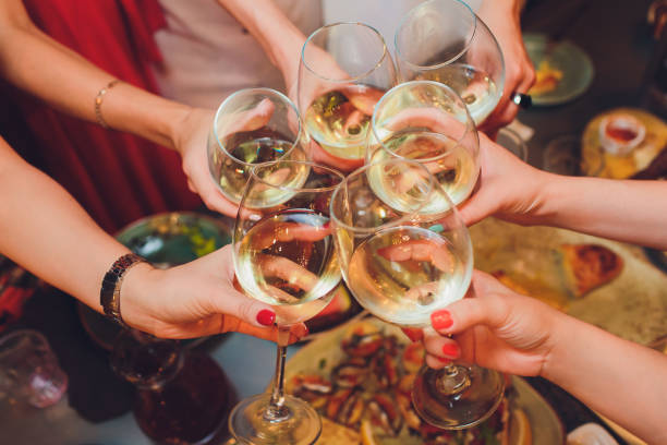 istock Human hands with glasses of red wine clinking them over served table. 1177943282