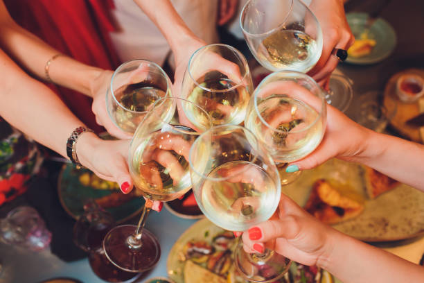 istock Human hands with glasses of red wine clinking them over served table. 1177943285