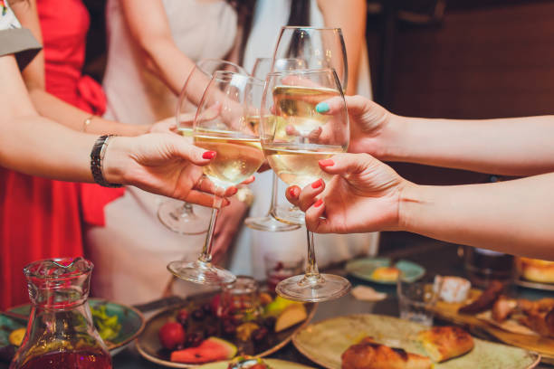 istock Human hands with glasses of red wine clinking them over served table. 1177943290
