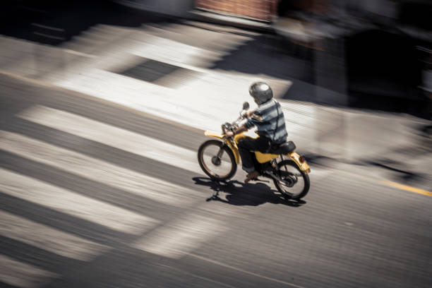 Anonymous man riding motorbike on street stock photo