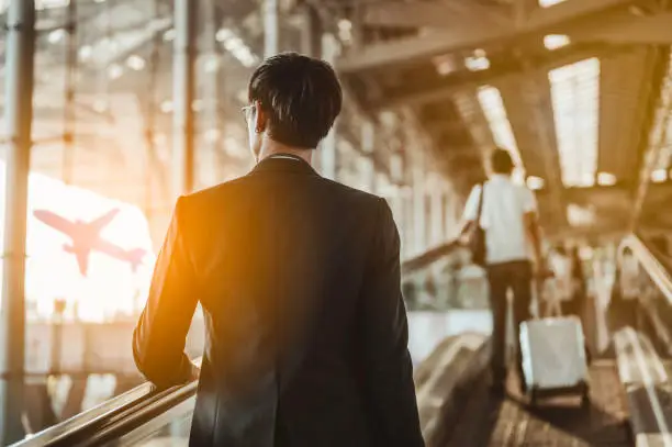 Photo of Businessman moving to terminal gate for check in boarding with luggage at the airport to business trip.