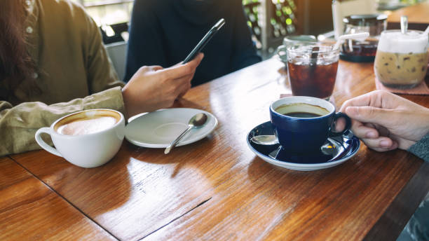 istock people using mobile phone and drinking coffee together in cafe 1177969612