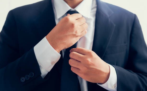 istock Businessman in black suit and adjusting necktie. 1177969977