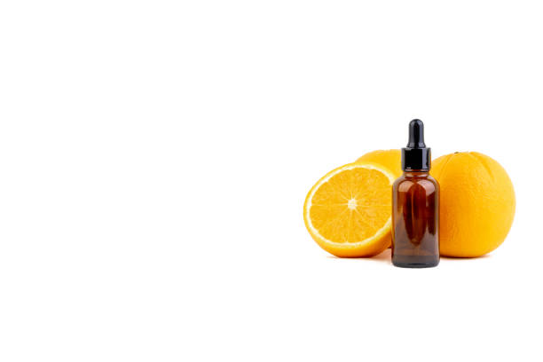 istock Vitamin C serum bottle with dropper and orange on white background. 1177973759
