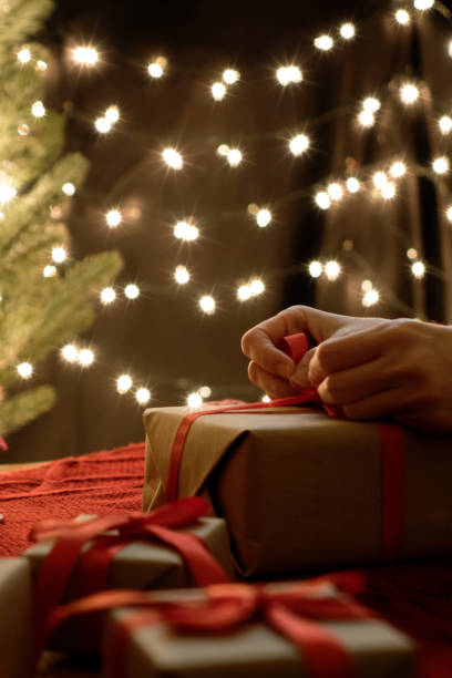istock Woman hand wrap christmas gift box with bokeh lights background 1177974550