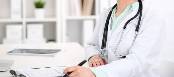 istock Stethoscope at female doctor breast at hospital office. Unknown physician's hands close-up. Medicine and health care concept. 1178001663