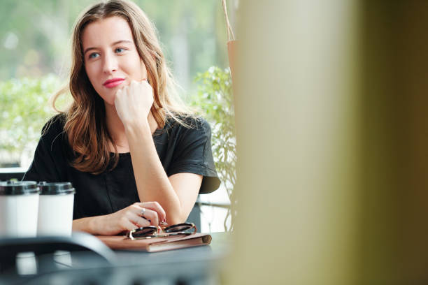 istock Pensive young woman at cafe table 1178004214