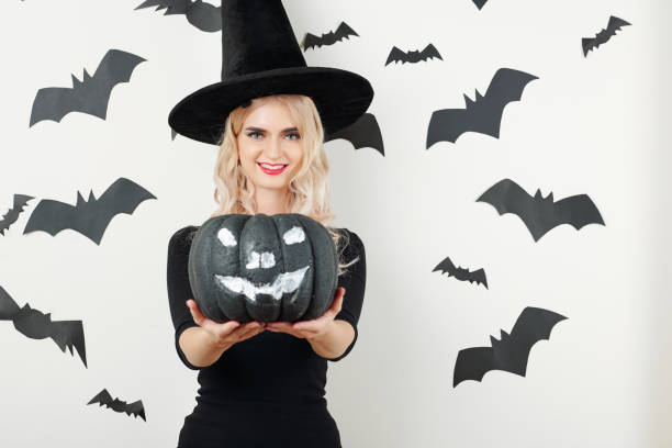 istock Sorceress holding black Halloween pumpkin 1178004633