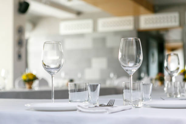 A front view of wine glasses and dishes in the restaurant table set stock photo
