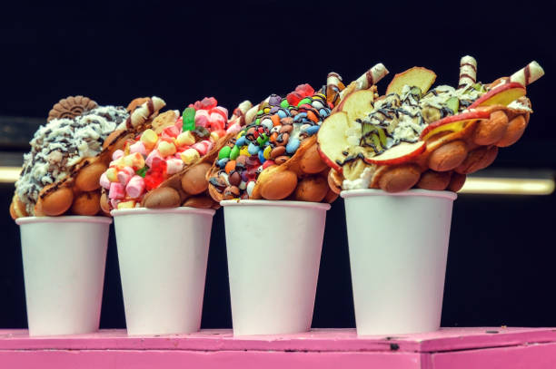 Close up. Bubble waffles with various sweet fillings (cookie, chocolate, marshmallow, fruit, M&M's).