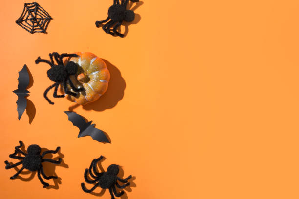 istock Halloween border with black spiders on orange background. Flat lay, top view, copy space. 1178011678