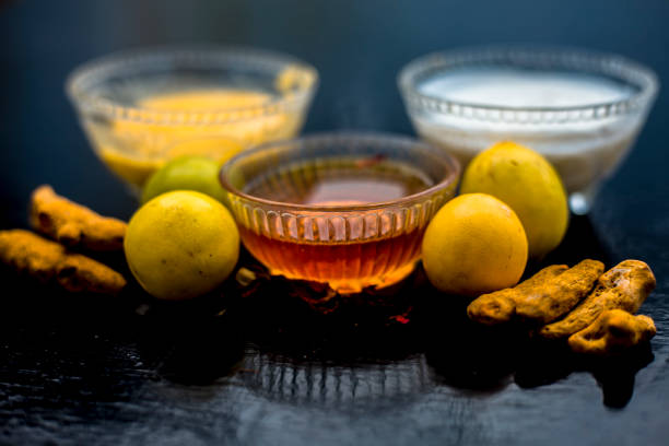 Face Mask Of Lemon Juice Honey And Curd Along With Some Raw Turmeric Well Mixed In A Glass Bowl Along With Entire Raw Ingredients On The Wooden Surface For Acneprone Skin And