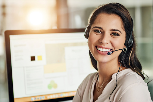 Cropped shot of an attractive young businesswoman wearing a headset and sitting alone in her office