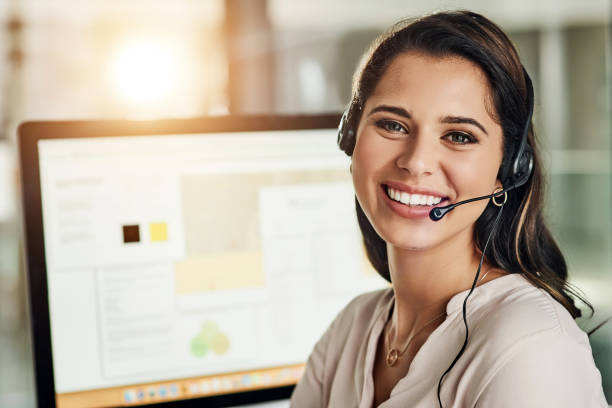 Climbing my way up the customer service ladder Cropped shot of an attractive young businesswoman wearing a headset and sitting alone in her office assistant photos stock pictures, royalty-free photos & images