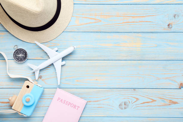 istock Airplane model with passport, compass, hat and camera toy on blue wooden table 1178014617