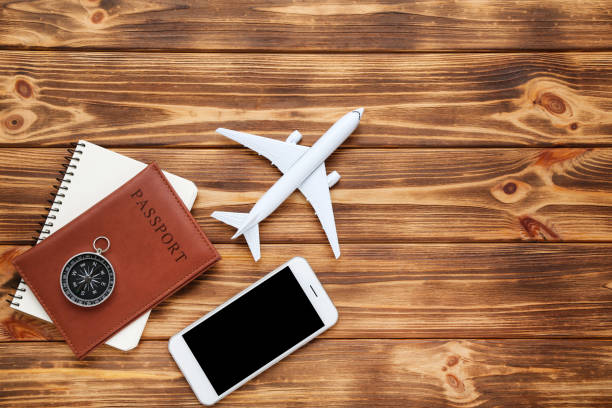 istock Airplane model with passport, smartphone and compass on brown wooden table 1178014659