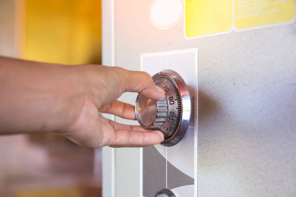 plate safe lock combination. Close up of a woman hand hold and tuning on a combinations safe dial lock. plate safe lock combination. Close up of a woman hand hold and tuning on a combinations safe dial lock. combination lock stock pictures, royalty-free photos & images