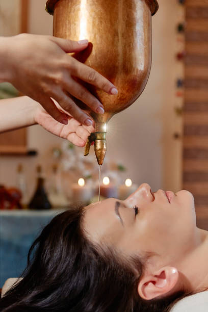 ayurvedic shirodhara procedure. indian massage on the ancient technique of shirodhara. the best of indian massage. - ayurveda massaging aromatherapy chakra imagens e fotografias de stock