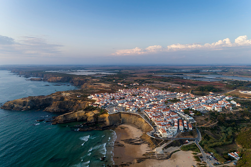 Vista aérea del pueblo de Zambujeira do Mar y playa al atardecer, en Alentejo photo