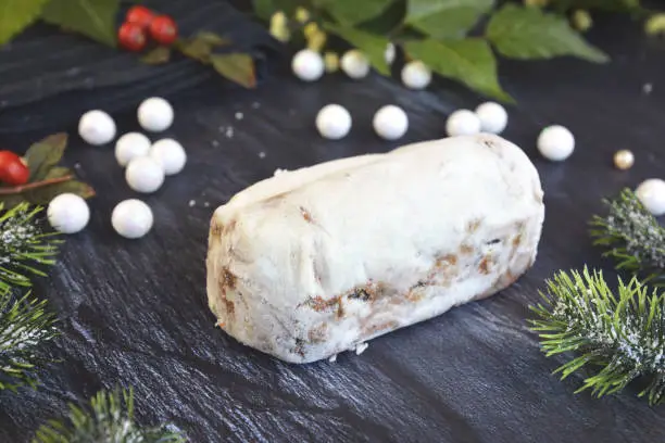 Photo of Full traditional German christmas season sweet food called 'Stollen' or 'Christstollen', a fruit bread of nuts, spices, and dried or candied fruit, coated with powdered sugar