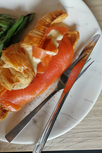 Breakfast smoked salmon with french toast croissant serve with fresh vegetable.