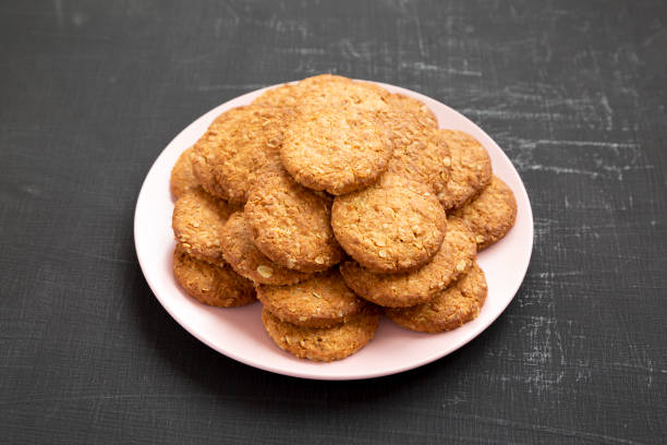 istock Cereal cookies on a pink plate on a black surface, side view. Closeup. 1178028771