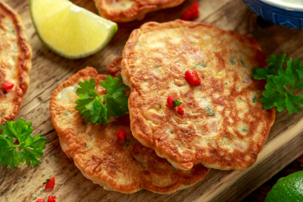 istock Corn fritters, pancake with dip white sauce, lime and chilli on wooden board 1178034873