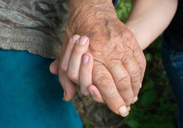 Old and young woman holding hands together. Hands. Close-up.