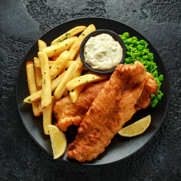 british traditional fish und chips mit erbsenpüree, tartarsauce und kaltem bier. - cod fillet fried prepared fish stock-fotos und bilder