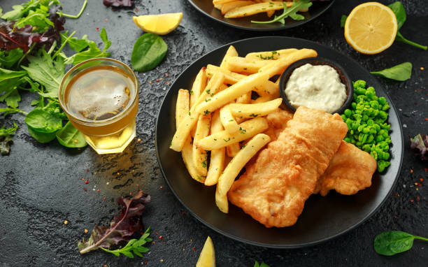 british traditional fish und chips mit erbsenpüree, tartarsauce und kaltem bier. - cod fillet fried prepared fish stock-fotos und bilder