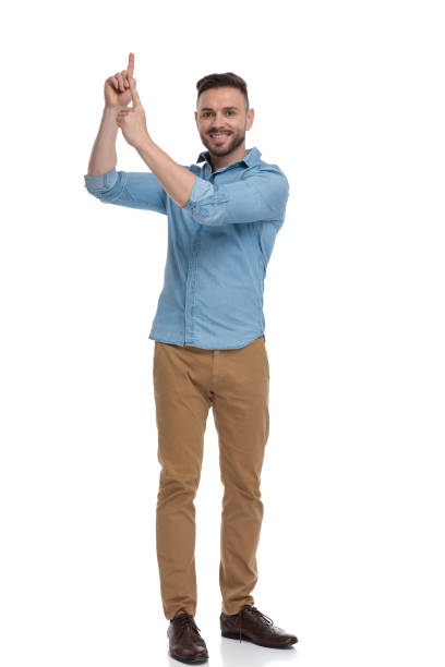 istock casual man standing and pointing up happy 1178037148