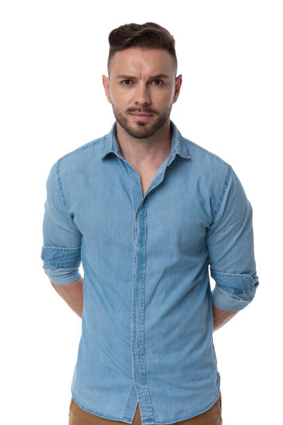 istock casual man standing with hands behind him mysterious 1178038091