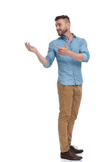 istock casual man with hands raised looking back over shoulder intrigued 1178038626