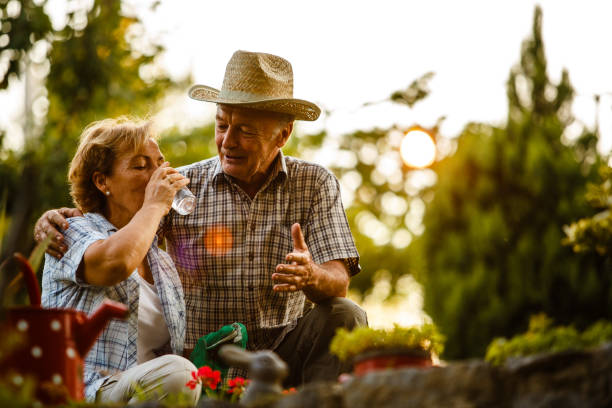 istock Senior woman drinking water while her husband embracing her. 1178039460