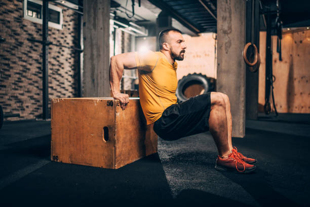 istock Buff male athlete doing dips workout on a box in a gym 1178042747