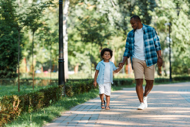 istock happy african american boy holding hands while walking with father 1178048205