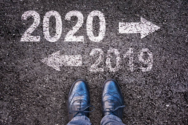 istock 2020 and 2019 with direction arrows written on an asphalt road background with legs 1178049249