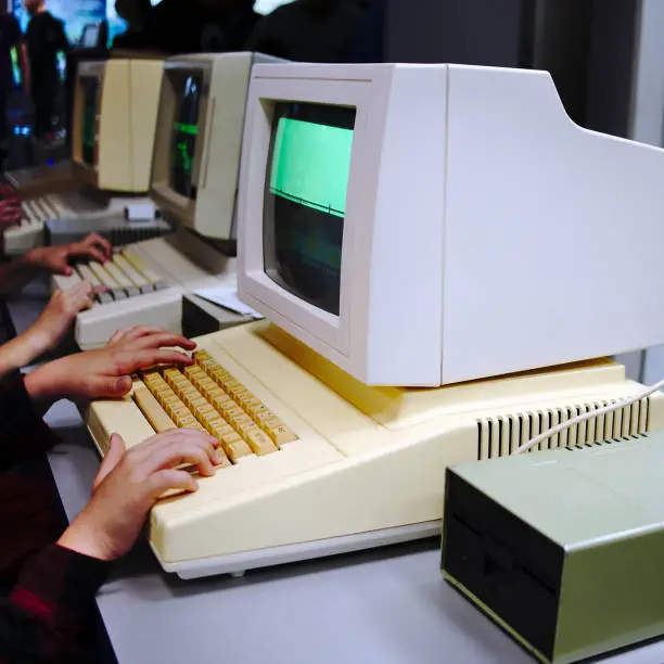 Children playing very old DOS games on vintage PS's. The monitor with visible screen is edited.