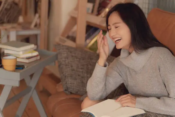 Japanese woman who reads a book and laughs