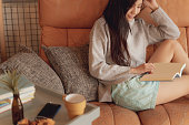 日本に住む若い女性は、落ち着いた空間のカフェで読む