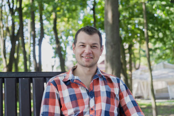 istock Young handsome man sits on a bench in a park 1178067342