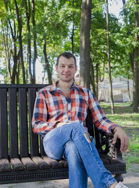 istock Young handsome man sits on a bench in a park 1178067920