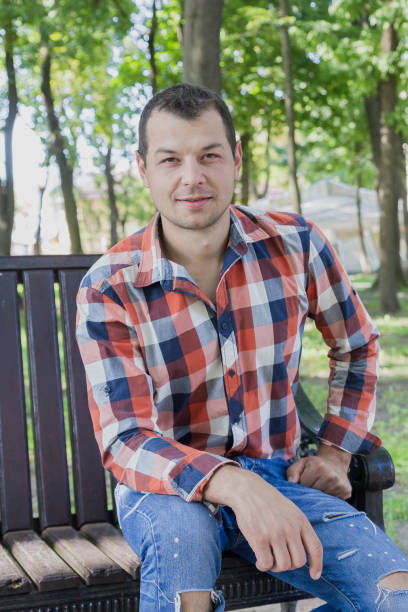 istock Young handsome man sits on a bench in a park 1178067995
