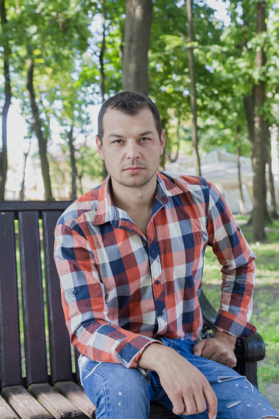 istock Young handsome man sits on a bench in a park 1178068015