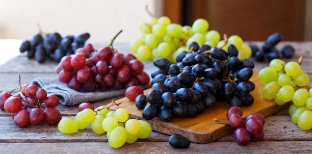 istock Assortment of fresh grape on cutting board. Grey wooden background. 1178069199