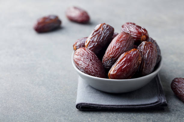 Fresh medjool dates in bowl. Grey background. Copy space. Fresh medjool dates in bowl. Grey background. Copy space date fruit stock pictures, royalty-free photos & images
