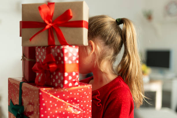 ragazza che porta una pila di regali di natale. ragazzo felice all'ora di natale. - christmas stack gift carrying foto e immagini stock