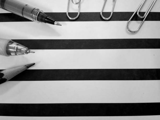 There are paper holder in black and white stripes, pen pencil and paper clips and also calculator with Thai coins in some pictures