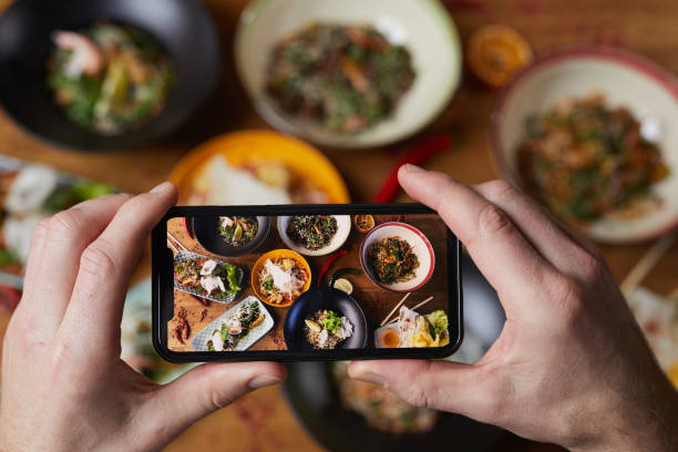 Smartphone Photo of Delicious Food Close up of unrecognizable man taking photo of delicious Asian food, focus on smartphone screen, copy space taiwan photos stock pictures, royalty-free photos & images